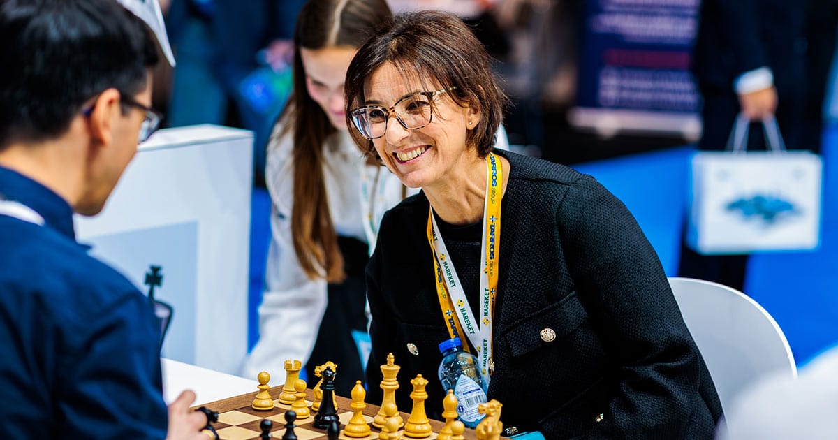 Smiling visitor playing chess at the WR Logistics booth