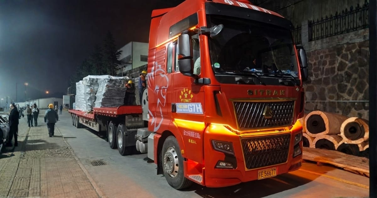 Heavy haul truck transporting oversized industrial equipment at night with escort crew
